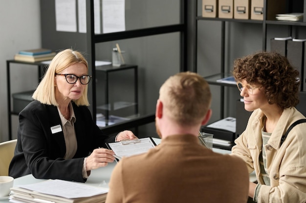 portrait mature female insurance broker consulting couple office holding application forms 622301 5690